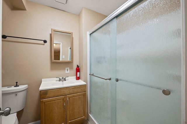 bathroom featuring walk in shower, vanity, and toilet