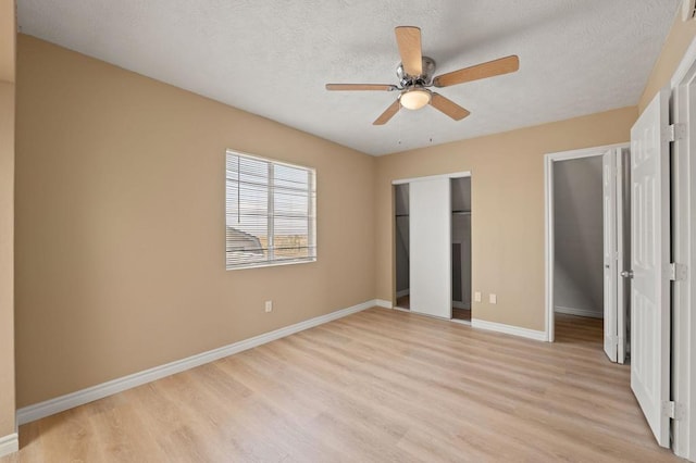 unfurnished bedroom with light wood-type flooring, ceiling fan, and a textured ceiling