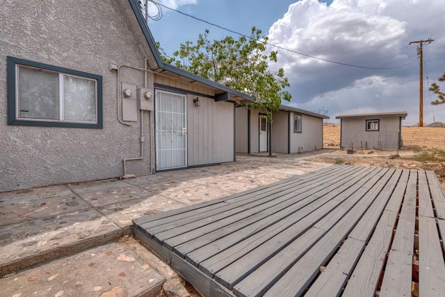 wooden deck featuring a storage unit and a patio