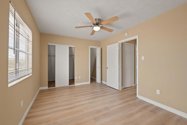 unfurnished bedroom with light wood-type flooring, ceiling fan, and a textured ceiling