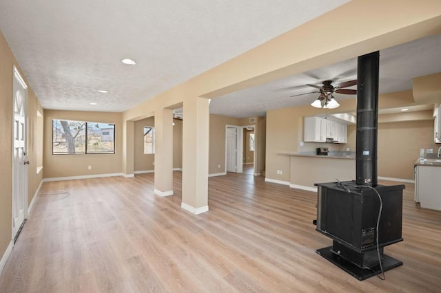 unfurnished living room with ceiling fan and light hardwood / wood-style floors