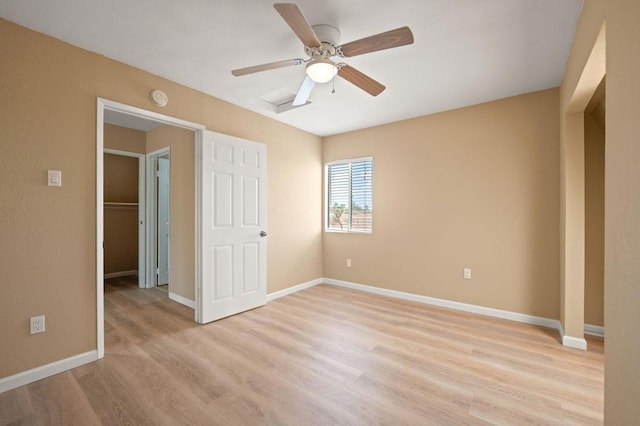 unfurnished bedroom with ceiling fan, light wood-type flooring, and a closet