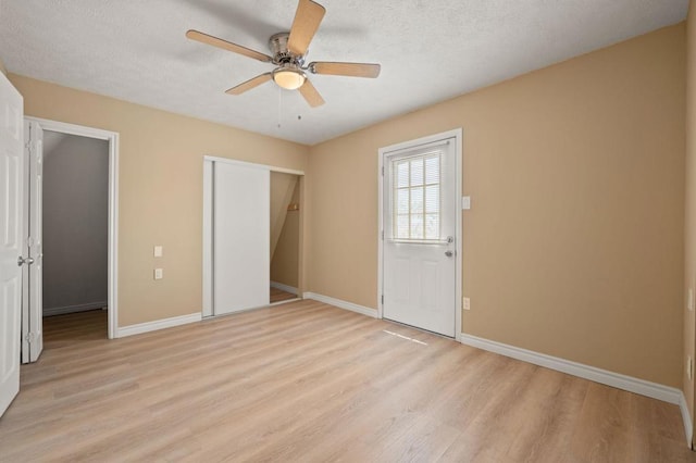 unfurnished bedroom with a textured ceiling, ceiling fan, and light hardwood / wood-style floors