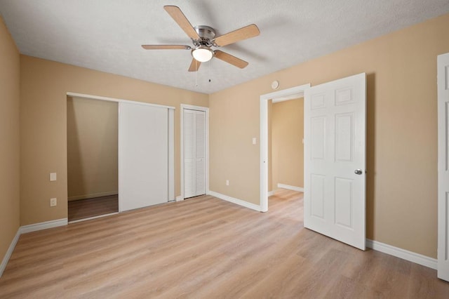 unfurnished bedroom with light wood-type flooring, ceiling fan, and a textured ceiling