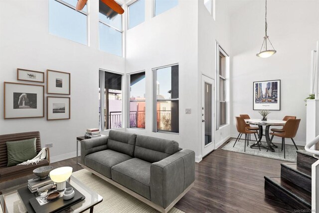 living room featuring dark wood-type flooring and a high ceiling