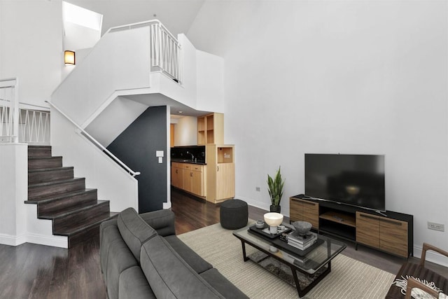 living room with dark wood-type flooring and a high ceiling