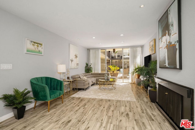 living room featuring light wood-type flooring and expansive windows