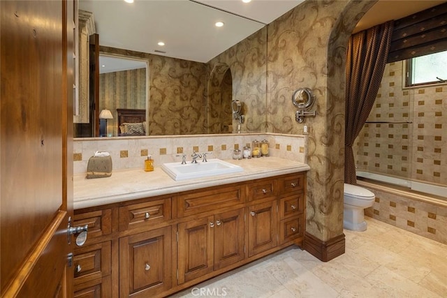 full bathroom featuring toilet, vanity, and tiled shower / bath