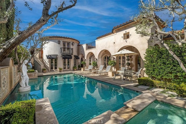 rear view of house with a balcony and a patio area