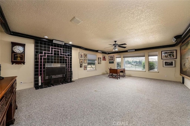 unfurnished living room featuring a textured ceiling, ceiling fan, carpet flooring, and a fireplace