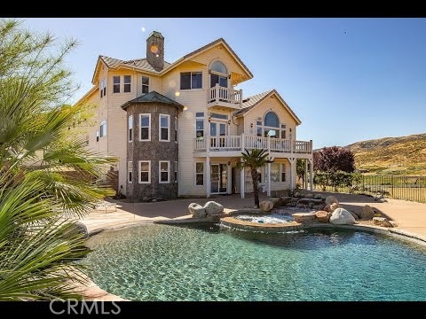 back of property with a fenced in pool, a balcony, a chimney, fence, and a patio area