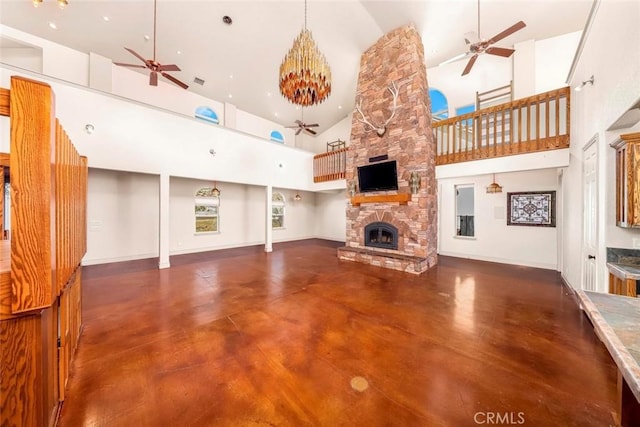 unfurnished living room featuring baseboards, ceiling fan, concrete flooring, a fireplace, and high vaulted ceiling