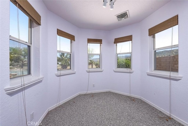 carpeted empty room with visible vents and baseboards