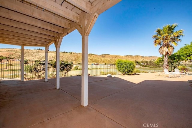 view of patio / terrace featuring fence and a mountain view