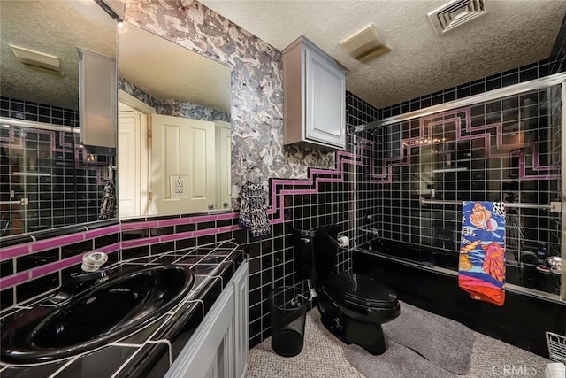 bathroom featuring visible vents, toilet, enclosed tub / shower combo, a textured ceiling, and vanity