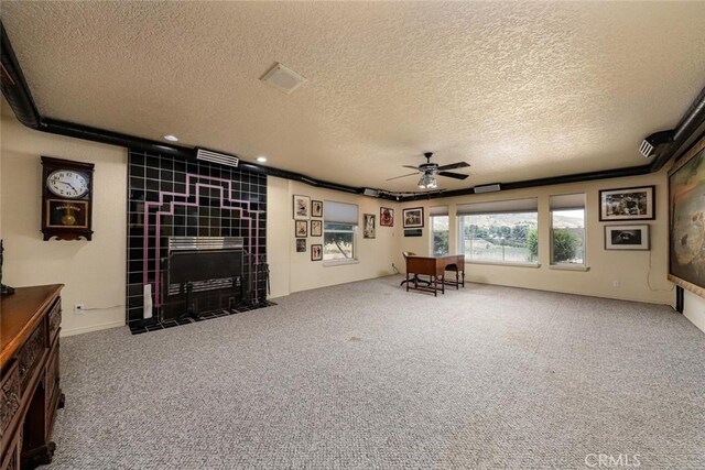 unfurnished room with a textured ceiling, recessed lighting, carpet floors, a ceiling fan, and a tiled fireplace