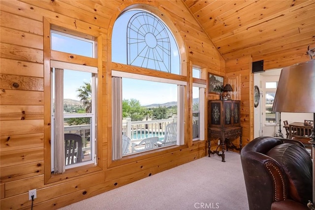 living area featuring carpet floors, high vaulted ceiling, wood ceiling, and wooden walls