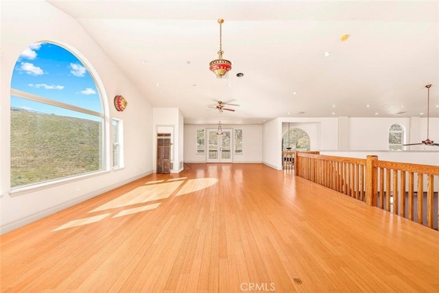 unfurnished living room with baseboards, light wood-style flooring, and a ceiling fan