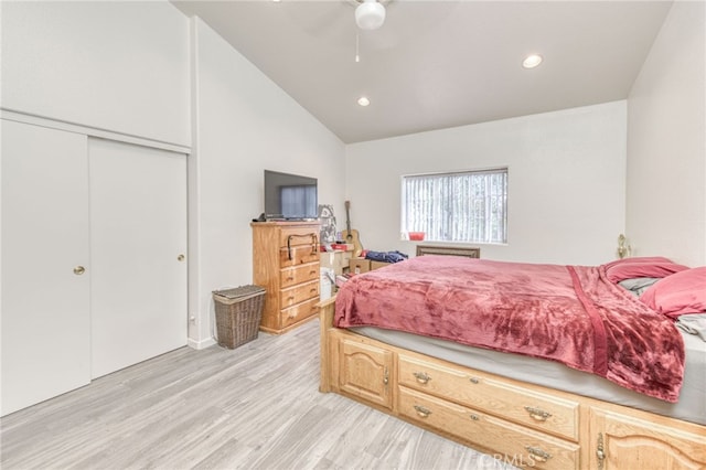 bedroom featuring vaulted ceiling, a closet, light hardwood / wood-style flooring, and ceiling fan