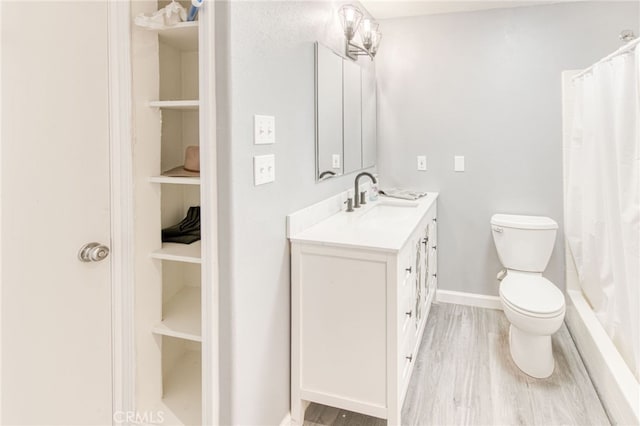 bathroom featuring toilet, vanity, hardwood / wood-style flooring, built in features, and curtained shower