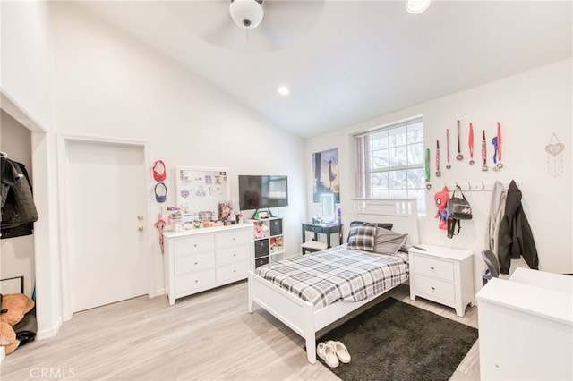 bedroom featuring ceiling fan, light hardwood / wood-style flooring, and high vaulted ceiling