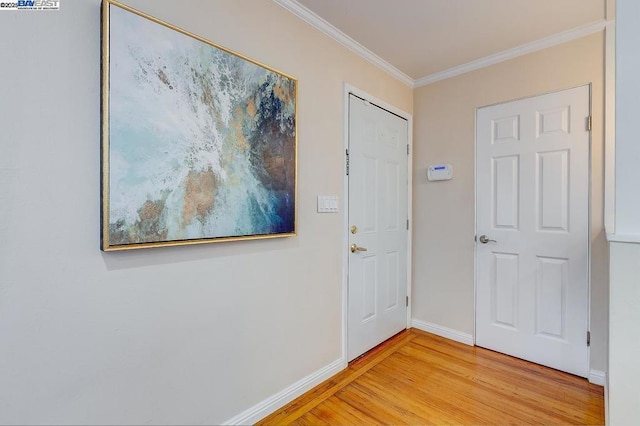 foyer entrance with hardwood / wood-style flooring and crown molding