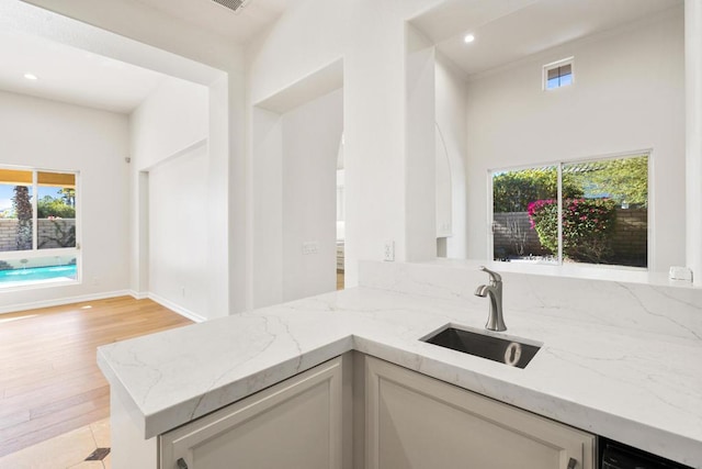 kitchen with light stone countertops, sink, and light tile patterned flooring