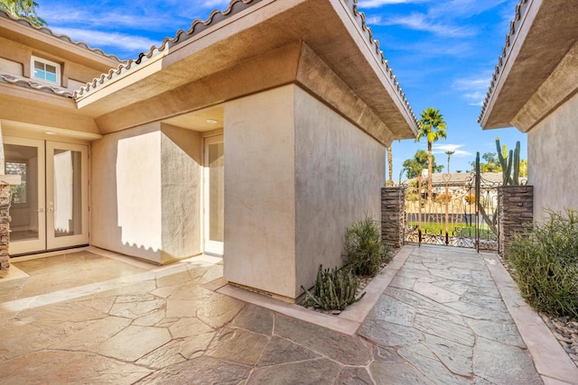 view of property exterior with french doors and a patio