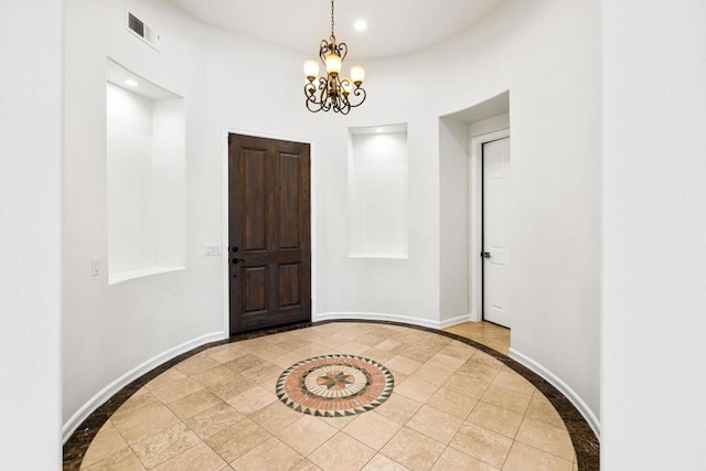 tiled entrance foyer featuring a chandelier