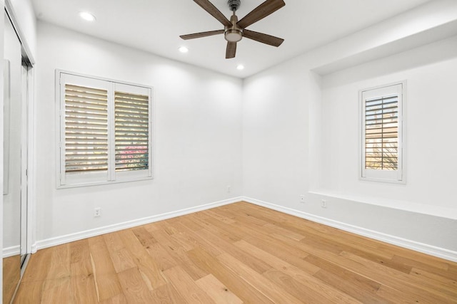 empty room with ceiling fan and light hardwood / wood-style flooring