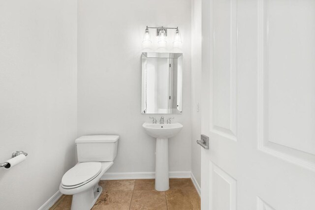 bathroom featuring sink, toilet, and tile patterned flooring