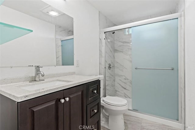 full bathroom featuring a marble finish shower, toilet, marble finish floor, and vanity