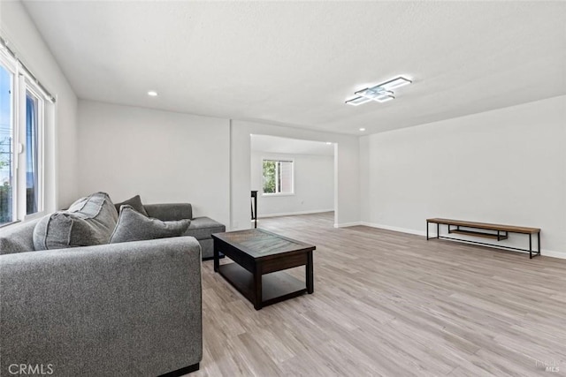 living room with recessed lighting, baseboards, and light wood-style floors