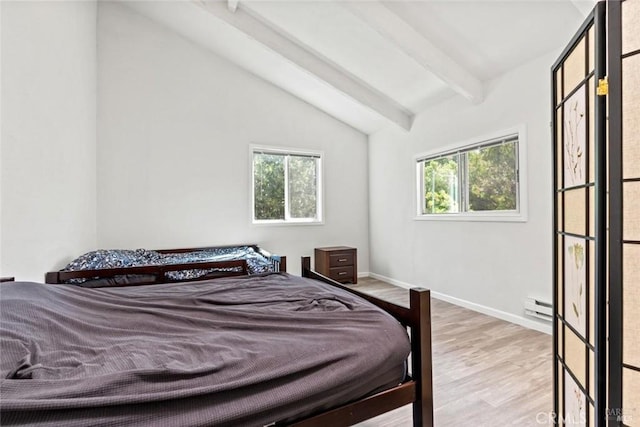 bedroom featuring a baseboard heating unit, multiple windows, vaulted ceiling with beams, and wood finished floors