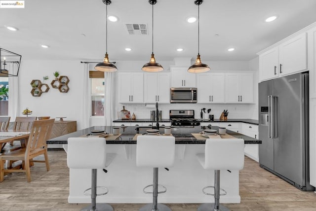 kitchen with hanging light fixtures, stainless steel appliances, and a kitchen island