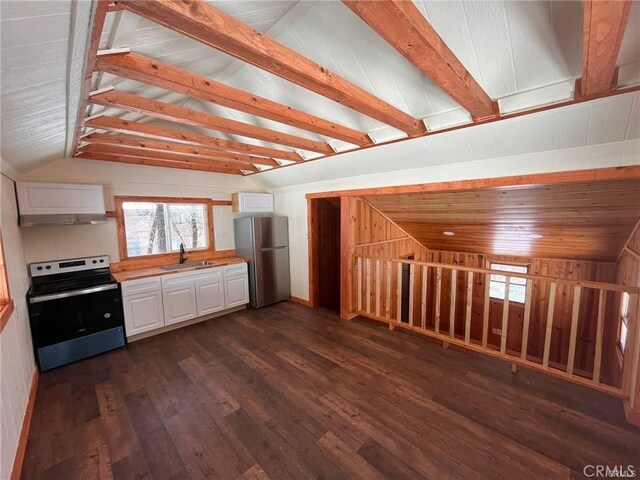 kitchen featuring white cabinets, stainless steel appliances, and vaulted ceiling with beams