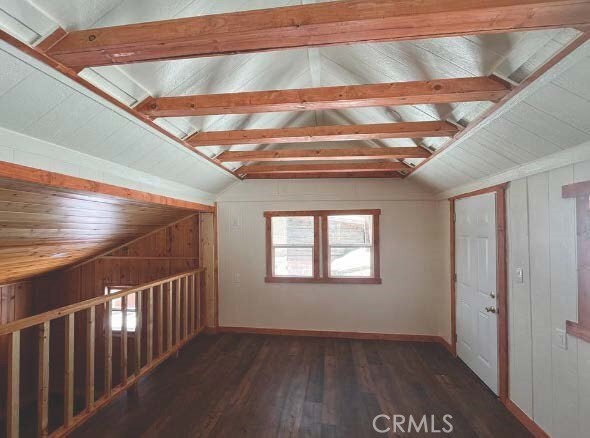 bonus room with dark hardwood / wood-style floors, lofted ceiling, and wooden walls