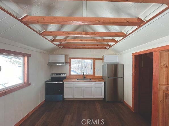 kitchen featuring stainless steel appliances, lofted ceiling, white cabinets, and sink