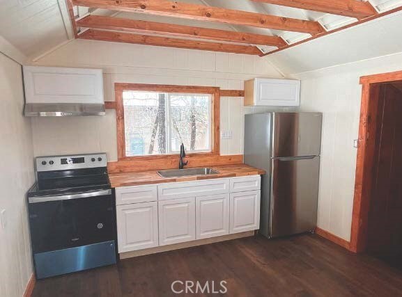 kitchen featuring butcher block counters, appliances with stainless steel finishes, sink, and white cabinetry