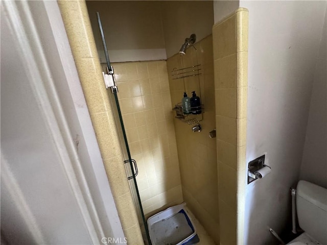 bathroom with toilet and a tile shower