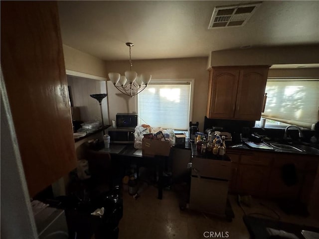 kitchen featuring sink, a notable chandelier, and decorative light fixtures