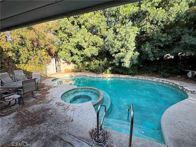 view of swimming pool with an in ground hot tub