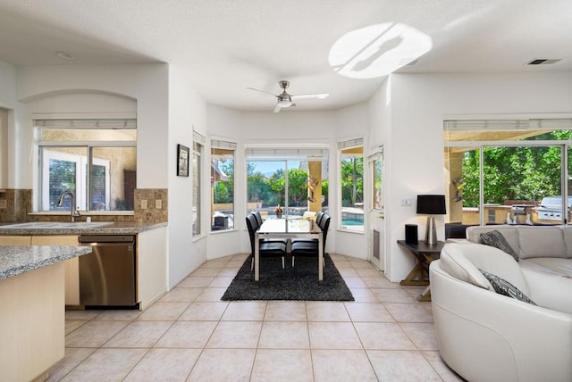 tiled dining space with ceiling fan and sink