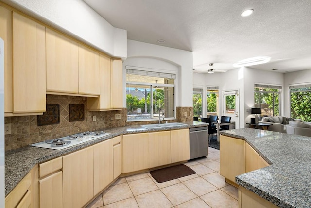 kitchen featuring ceiling fan, decorative backsplash, light brown cabinets, dishwasher, and white gas stovetop