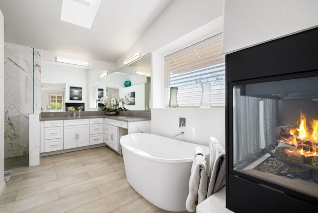 bathroom featuring plenty of natural light, vanity, separate shower and tub, and vaulted ceiling