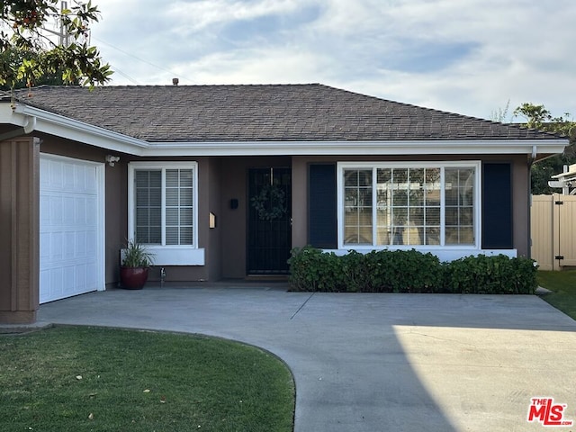 ranch-style home featuring a front lawn and a garage