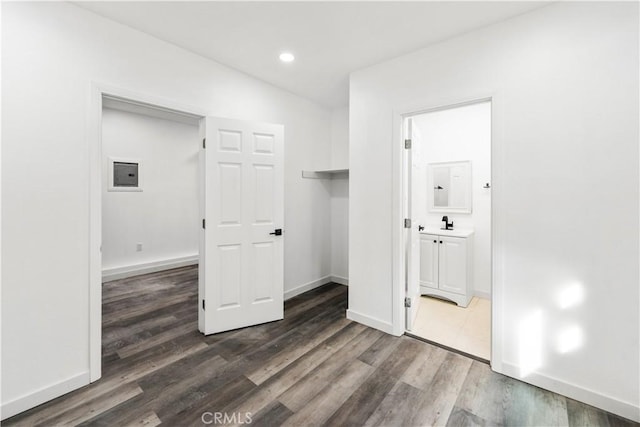 laundry area with dark wood-type flooring, electric panel, and sink