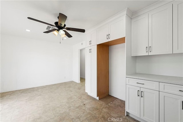 kitchen with ceiling fan and white cabinets