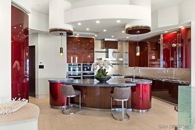 bar featuring sink, dark stone countertops, a towering ceiling, and decorative light fixtures