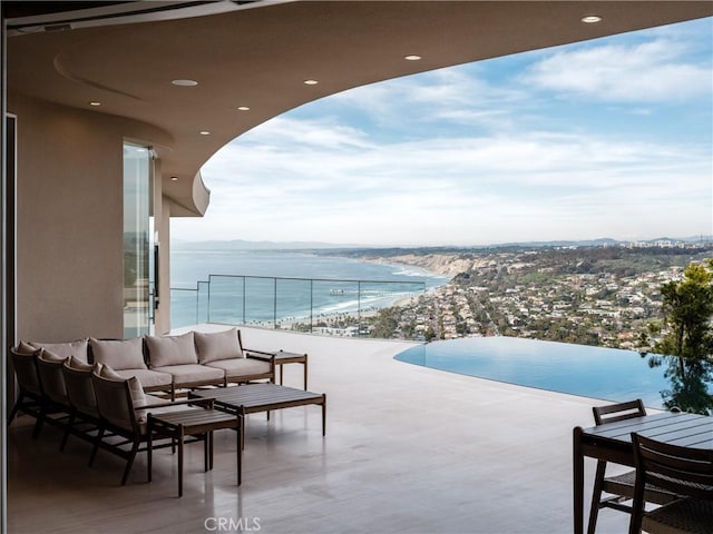 exterior space featuring an outdoor living space, a water view, and a beach view